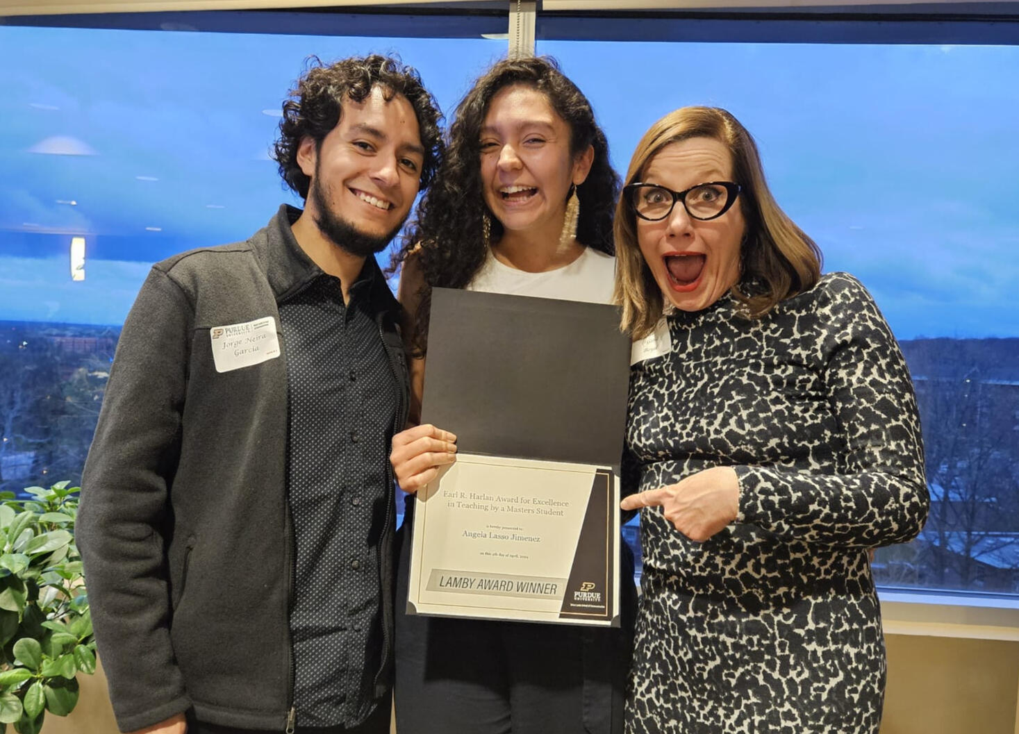 Lamby's Banquet Award, 2024 Photo of three people in which Angela is receiving an award for Excellence in Teaching. Blue background, happy faces.